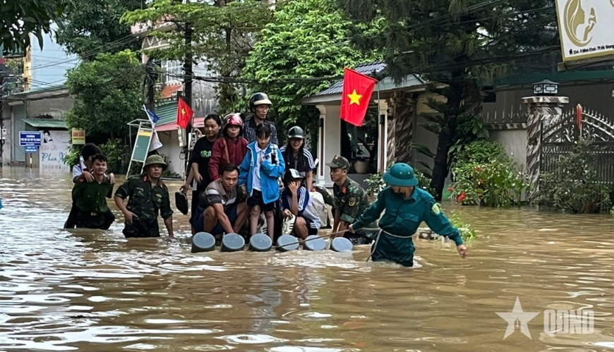 Cán bộ, chiến sĩ Bộ CHQS tỉnh Tuyên Quang đưa người dân ở vùng ngập sâu đến vị trí an toàn. Ảnh: CHUNG THỦY